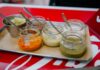 Sosy z kuchni świata, które odmienią codzienny obiad: od chimichurri po teriyaki Kolorowe sosy świata w szklanych słoiczkach z łyżeczkami na tacy