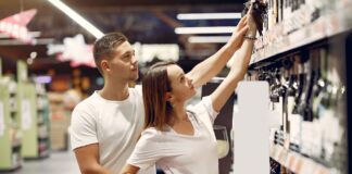 Para wybierająca razem produkt z górnej półki w supermarkecie