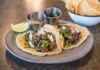 Zbliżenie na tacos z wołowiną, kolendrą i limonką na talerzu