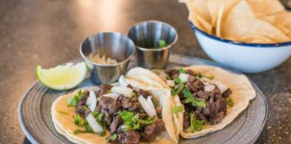 Sekrety kuchni meksykańskiej: taco, burrito i domowe tortille krok po kroku Zbliżenie na tacos z wołowiną, kolendrą i limonką na talerzu
