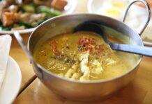 Czym różni się curry zielone, czerwone i żółte? Przewodnik po tajskich pastach Tajskie curry z kurczakiem i świeżymi ziołami w metalowej misce