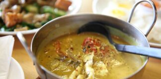 Czym różni się curry zielone, czerwone i żółte? Przewodnik po tajskich pastach Tajskie curry z kurczakiem i świeżymi ziołami w metalowej misce