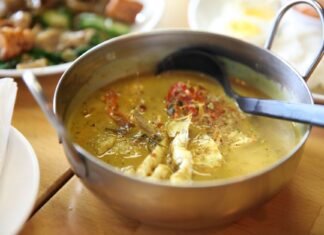 Czym różni się curry zielone, czerwone i żółte? Przewodnik po tajskich pastach Tajskie curry z kurczakiem i świeżymi ziołami w metalowej misce